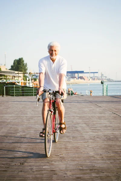 Handsome senior man riding bike