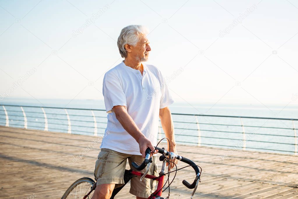 Handsome senior man riding bike