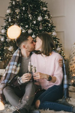 Genç güzel öpüşme ve bardak şampanya, kapalı ile Noel kutlamaları için zevk çift