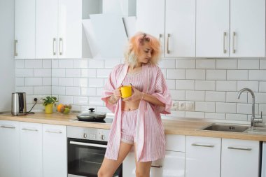 Pembe pijama beyaz loft mutfakta dururken çay içme pembe saçlı genç güzel kız