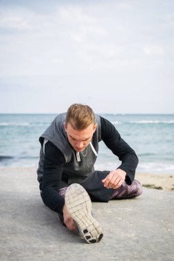 Denize sıfır plaj üzerinde Parkour hile yapan genç erkek