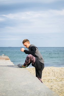 Denize sıfır plaj üzerinde Parkour hile yapan genç erkek