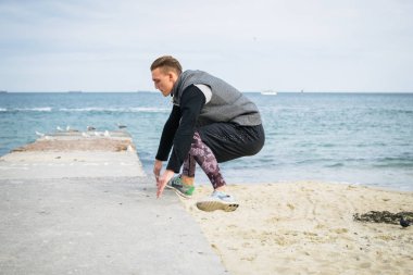 Denize sıfır plaj üzerinde Parkour hile yapan genç erkek