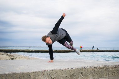 Denize sıfır plaj üzerinde Parkour hile yapan genç erkek