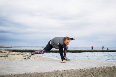 Denize sıfır plaj üzerinde Parkour hile yapan genç erkek