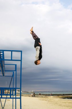 Denize sıfır plaj Backflip parkour hile yapan genç erkek