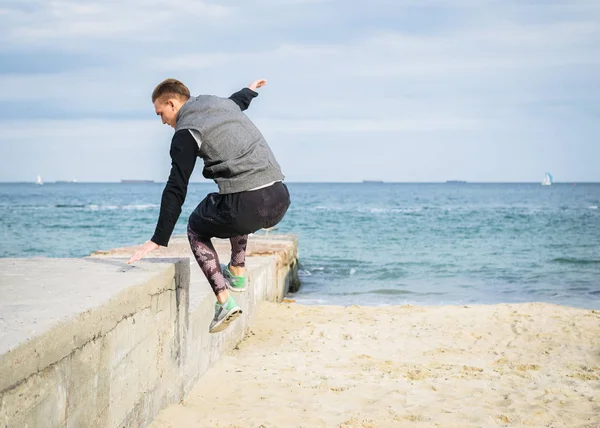 Denize sıfır plaj üzerinde Parkour hile yapan genç erkek