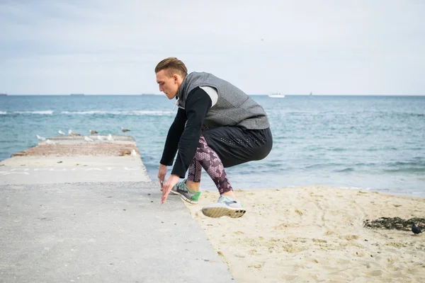 Denize sıfır plaj üzerinde Parkour hile yapan genç erkek