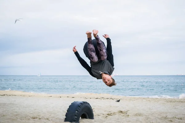 Jovem Fazendo Truques Parkour Praia Perto Mar — Fotografia de Stock