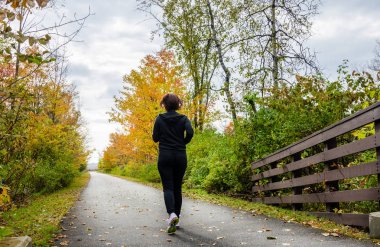 Asfalt bir yolda çalışan genç kadın