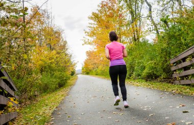 Genç kadın bir bulutlu sonbahar gününde koşu