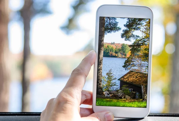 Tomar fotos con un Smartphone de un lago de montaña en un día de otoño — Foto de Stock