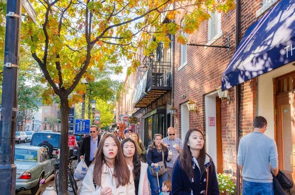 Les gens se promènent le long d'un trottoir bordé de boutiques et restaurant dans la vieille ville d'Alexandrie un jour d'automne ensoleillé — Photo