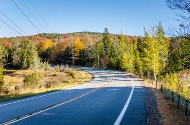 Eğri mavi gökyüzü altında bir dağ yolu üzerinde