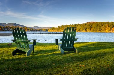 Günbatımında bir göl kıyısında'nın bahçesinde Adirondack sandalyeler