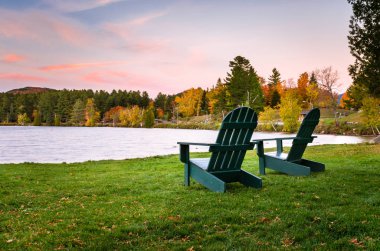 Alacakaranlıkta'nın bahçesinde boş Adirondack sandalyeler