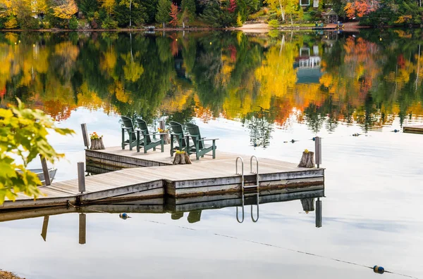 Chaises Adirondack vertes face à un lac à l'automne — Photo