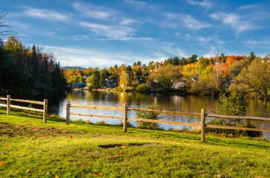 Ön planda bir çit ile sonbahar nehirde