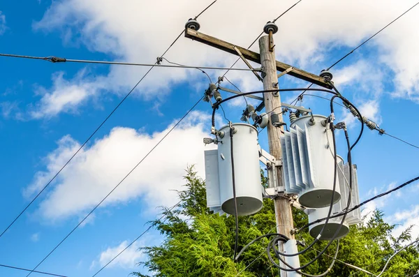 Bir kutup üst kısmında elektrik transformatörler — Stok fotoğraf