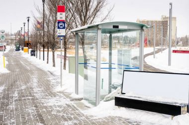 Otobüs durağı ile karlı bir kış gününde bir cam barınak Calgary, Kanada,