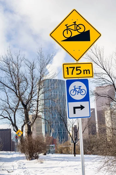 Road Signs along a Bicycle path Warning Cyclists against a Dangerous Steep Descent Ahead. Some Skyscrapers are Visible in Background. Calgary, Canada.