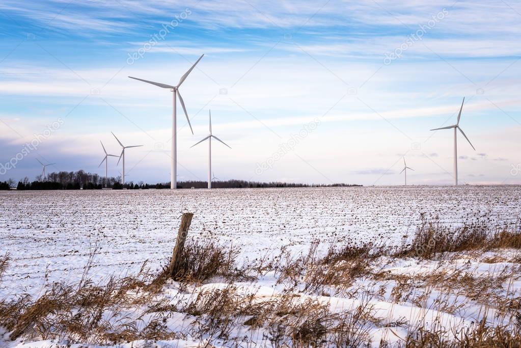 Wind Turbine for electricity Generation in a Snowy Field at Sunset. Renewable Energy Concept. Ontario, Canada.