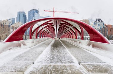 Calgary, Kanada - 11 Şubat 2017: insanlar barış Köprüsü bir dondurucu kış sabahı geçiş. Barış Köprüsü İspanyol mimar Santiago Calatrava, yayalar ve bisikletliler Bow Nehri geçerken barındıran tarafından tasarlanmış bir, köprüdür