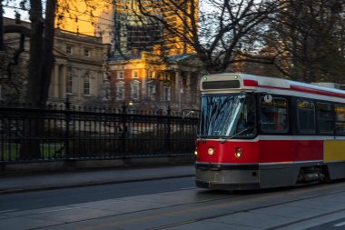 Old Colourful Tram In Motion at Sunset. Toronto, ON, Canada. clipart