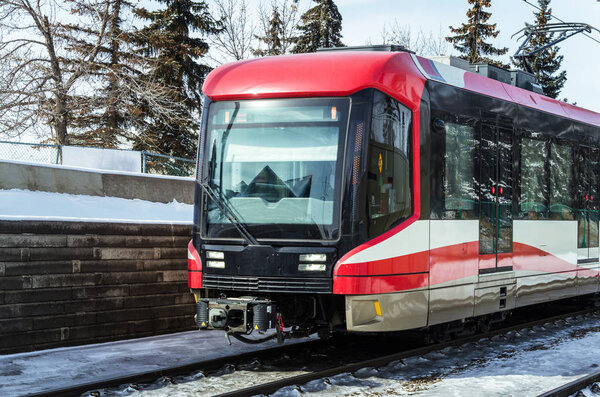 Light Rail Train on Tracks covered in Snown on a Sunny Winter Day
