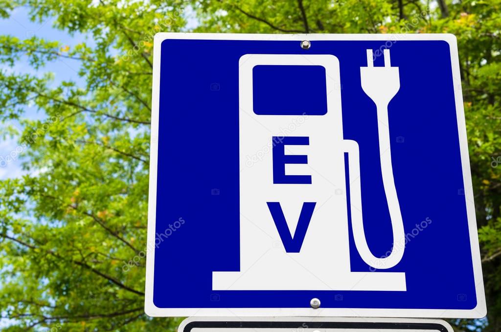 Electric Vehicle Recharging Station Sign with Green Trees in Background. Ecological Mode of Transport