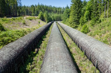 Güneşli bir yaz gününde hidroelektrik bir bitkinin eski Overground su boruları