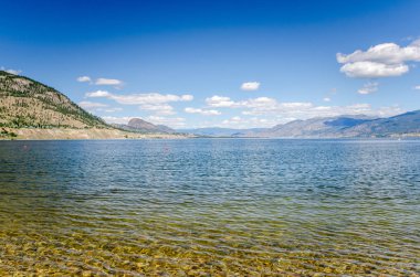Okanagan Gölü güneşli bir yaz sabahı bulutlar ile mavi gökyüzünün altında. Penticton, Bc, Kanada