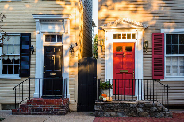 Винтажные входные двери двух старых домов в районе Александрия, штат Вирджиния, на закате
