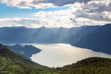 Parçalı bulutlu bir yaz gününde Howe Sound ve etrafındaki yüksek dağların görkemli manzarası. Squamish, Bc, Kanada.