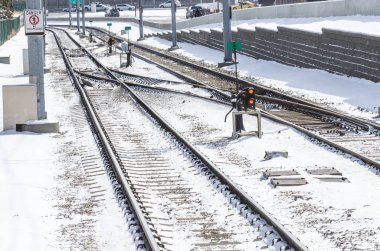Güneşli bir sabahta, bir yola paralel giden karlı tren yolu boyunca geçiş yapar. Calgary, Ab, Kanada.