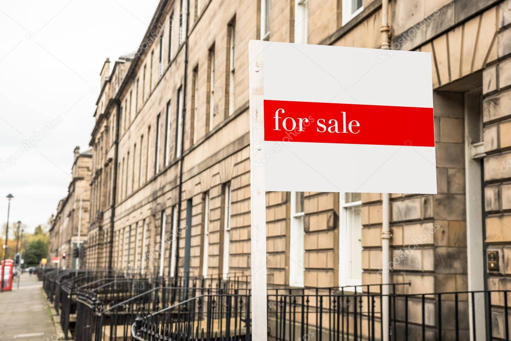 Real estate sign outside a stone terraced house on sale in a city centre on a cloudy autumn day. Edinburgh, Scotland, UK.