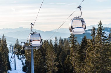 Boş teleferik kışın Alpler 'de karlı bir orman manzarası seyrediyor. Dolomitler, Güney Tyrol.