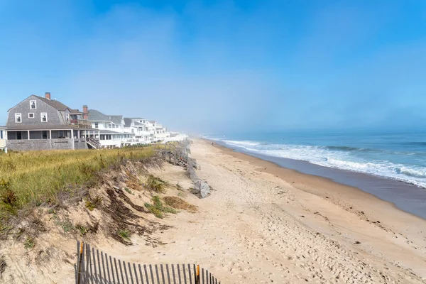 Sandy beach on the coast of New Hampshire on a misty autumn morning. Holiday homes line the beach. Seabrook, NH, USA.