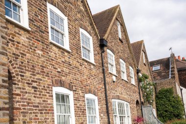 Bulutlu bir bahar gününde geleneksel İngiliz tuğlalı teraslı evlerin ayrıntıları. Londra, Uk.