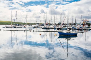 Parçalı bulutlu bir yaz gününde limanda bağlı yatlar. Stromness, Orkney, İskoçya, Uk.