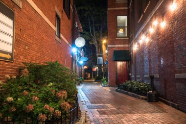 Geceleri zemin katında restoranları olan eski tuğladan binalarla dolu dar bir sokak. Portsmouth, NH, ABD.