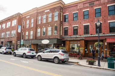 Güneşli bir sonbahar sabahı cadde boyunca mağazaları ve restoranları olan geleneksel tuğla binalar. Montpelier, VT, ABD.
