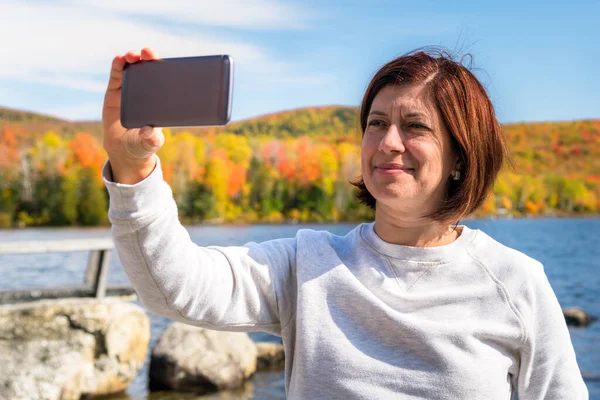 Mujer Tomando Selfie Orilla Lago Rodeado Bosques Pico Del Follaje — Foto de Stock