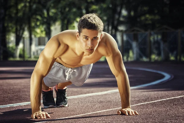 Aantrekkelijke fitness man doen oefeningen in park — Stockfoto