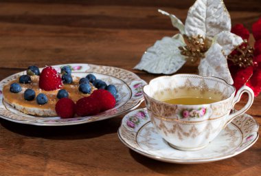 Fincan çay, sauser, pirinç kraker fıstık ezmesi, çilek ve