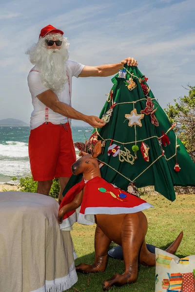 Père Noël détient des boîtes-cadeaux avec l'océan sur backgraund — Photo