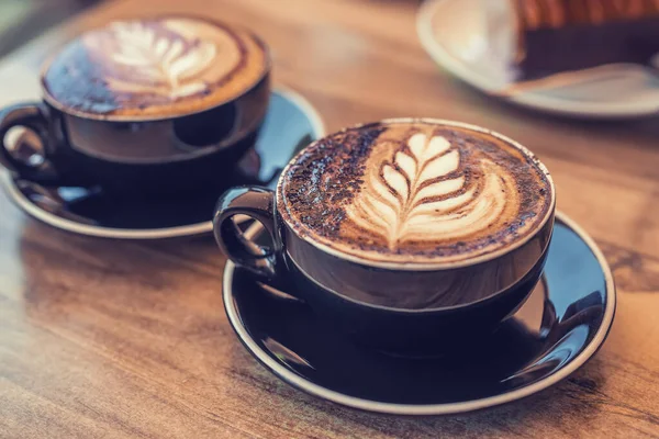 Zwei Tassen Kaffee mit Kunst auf einem Tisch — Stockfoto