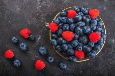 Taze yaban mersini ve çilek, arka plandaki cam kasede.