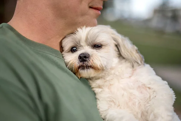 Man holding dog on a chest