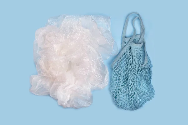 String reusable bags and a pile of plastic bags — Stock Photo, Image